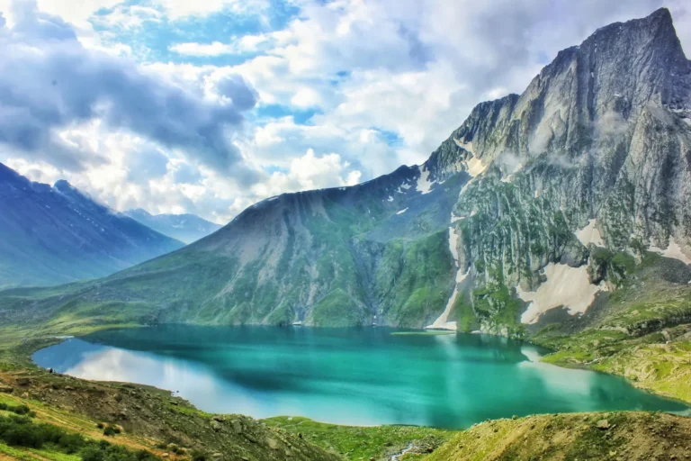 Turquoise alpine lake below a rocky peak in the Kashmir high mountains