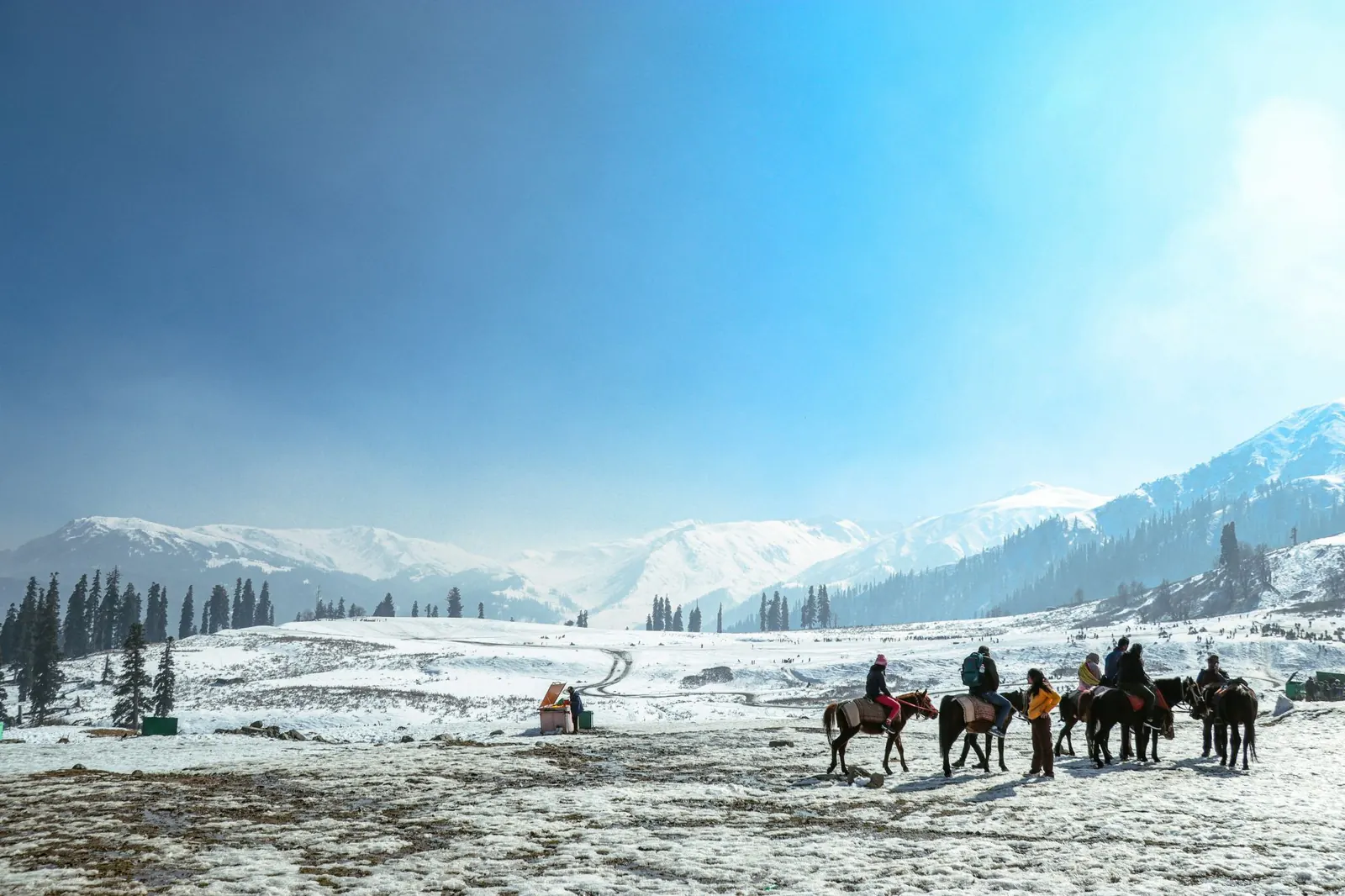 Pony rides across the snowfields of Gulmarg under a bright winter sky
