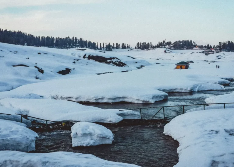 Deep winter snow and a stream in the Gulmarg meadow