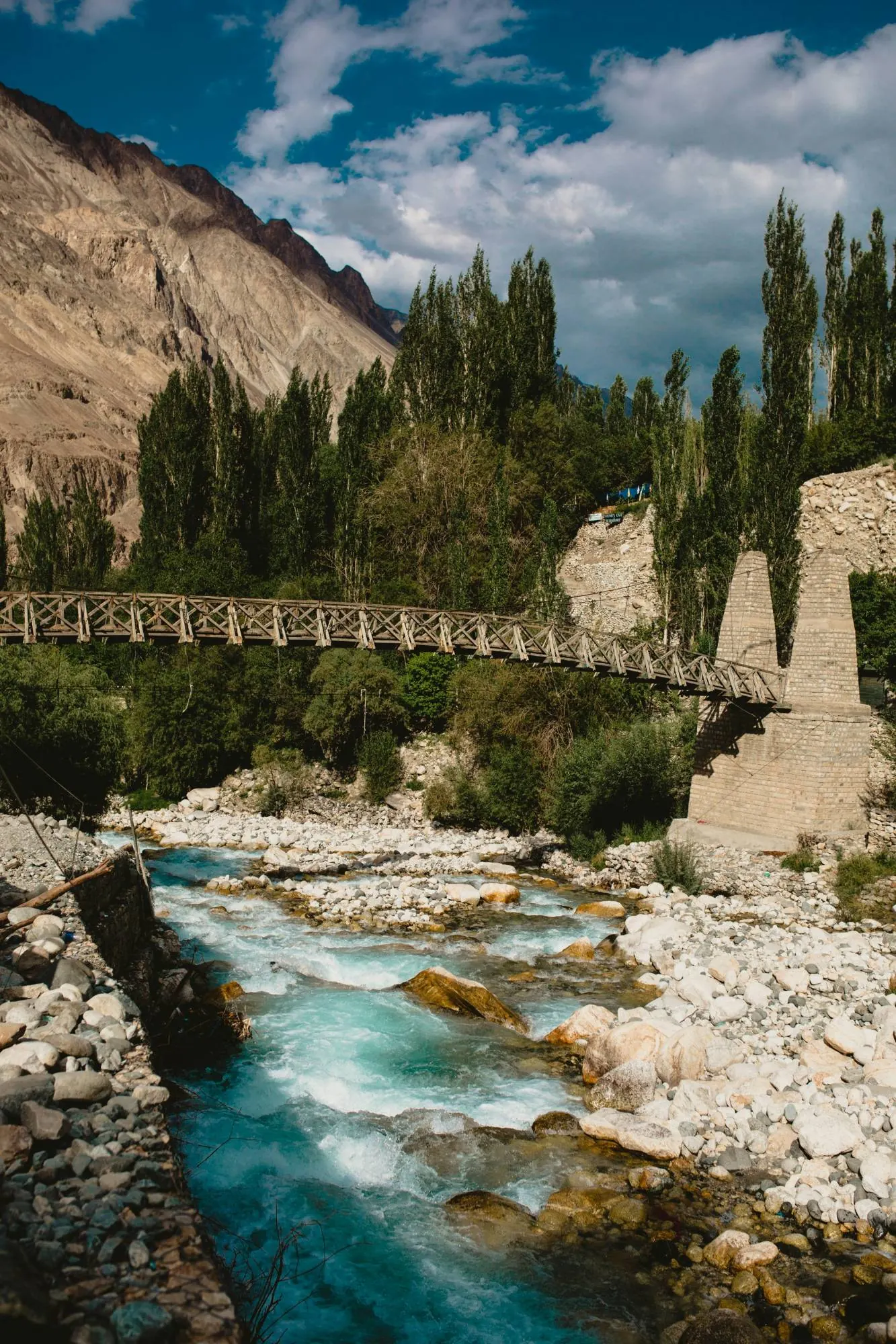Wooden suspension bridge over a glacial stream in Ladakh